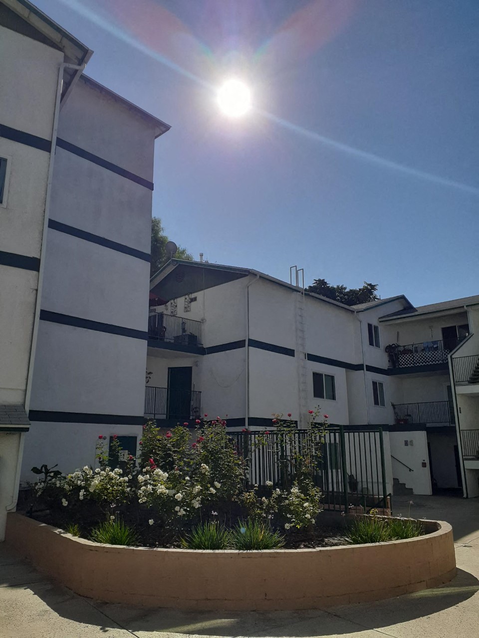 the sun is shining in the sky over an apartment building